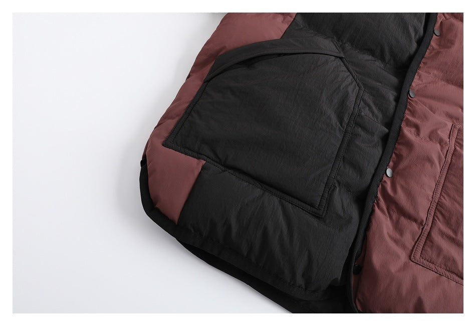 Close-up of a large black patch pocket on the burgundy-and-black padded jacket.