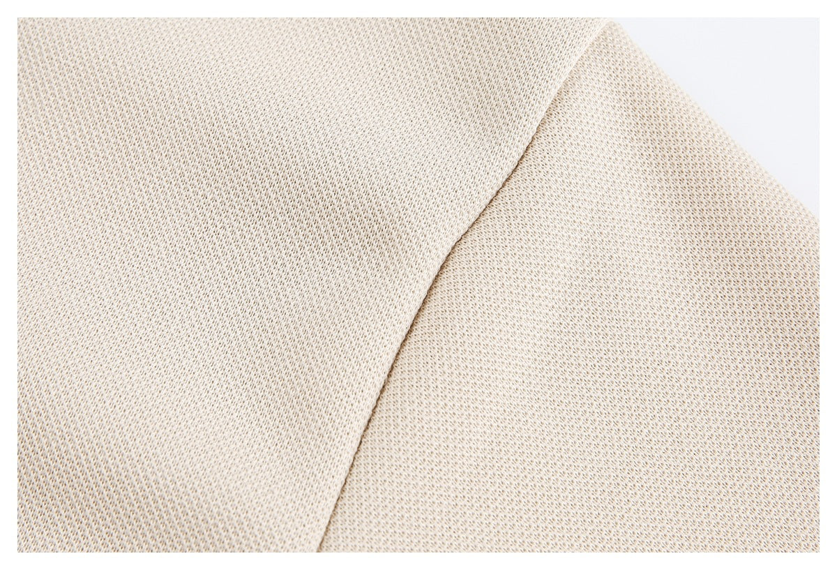 Close-up of cream knit fabric showing a curved seam and the garment's textured weave.