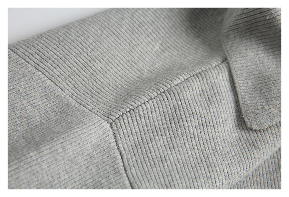Close-up showing a seam and ribbed knit construction on a light gray garment.