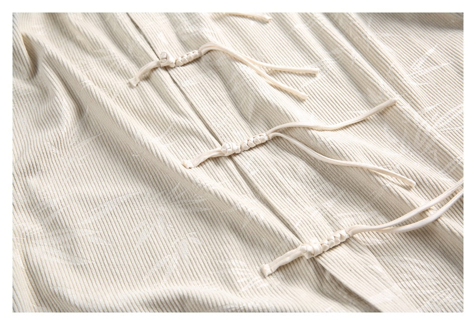Close-up of the cream tunic's front panel with several knotted frog closures.