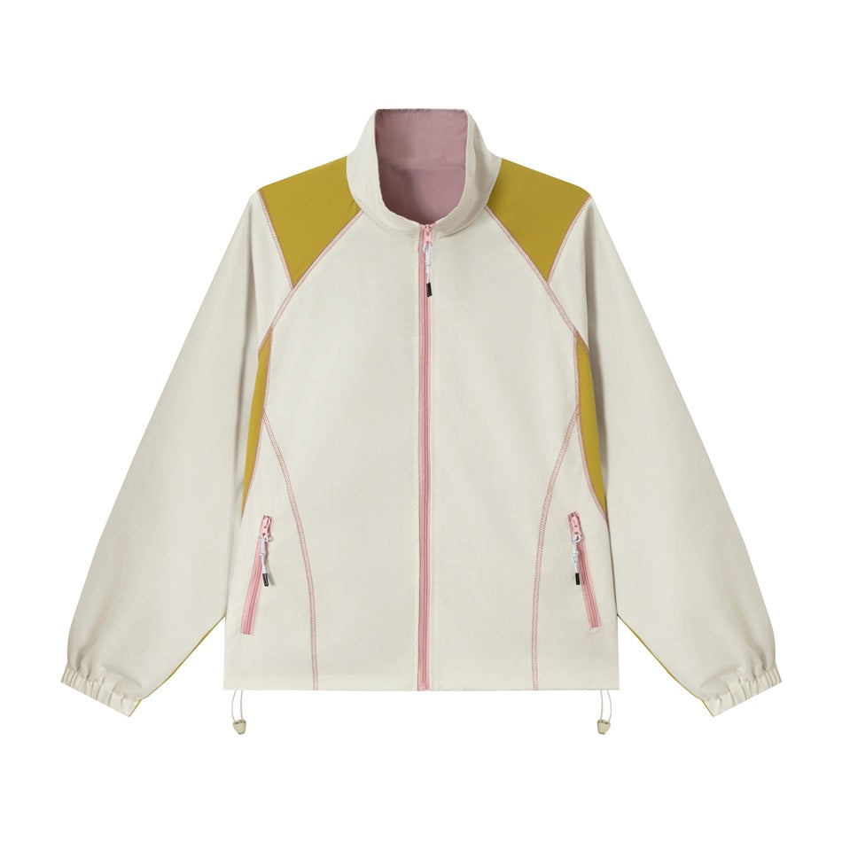 Beige zip-front stand-collar jacket with mustard panels, pink zips and stitching, and elastic cuffs