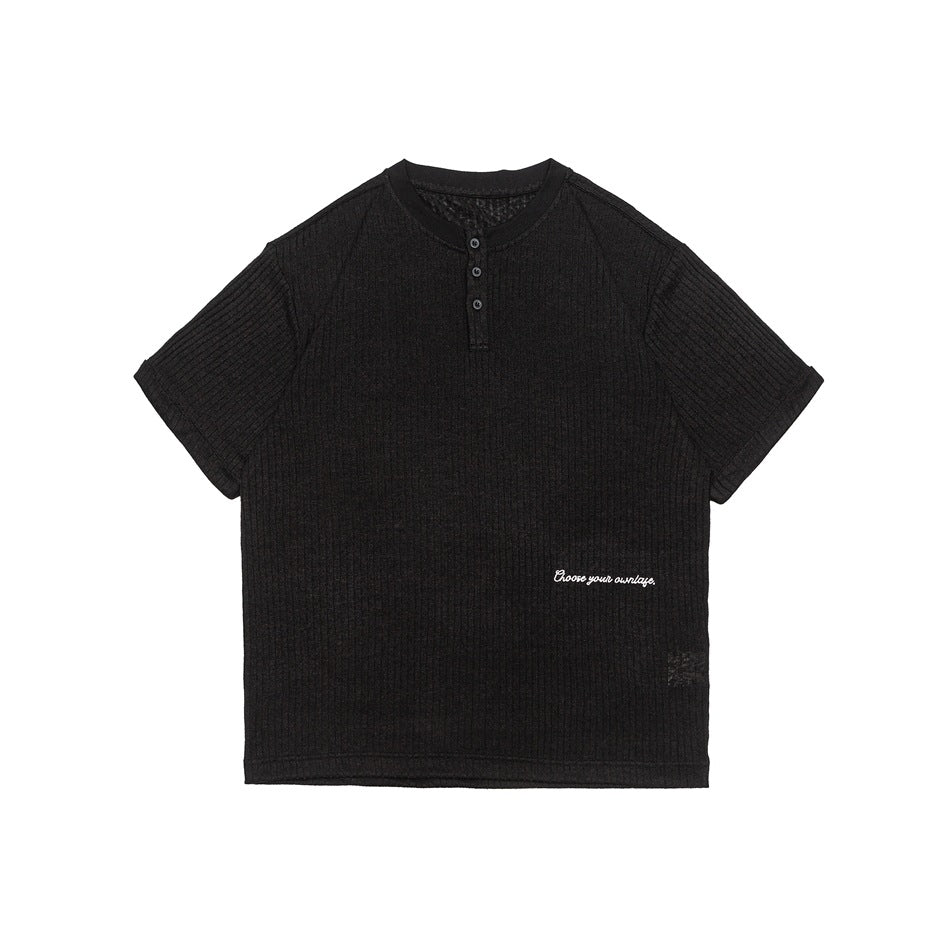 Black ribbed knit Henley short-sleeve top, front flat lay, with three buttons and small white script embroidery