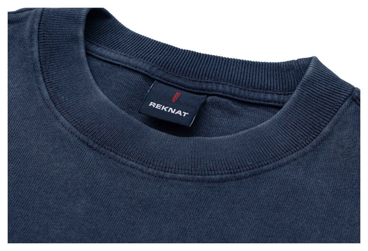 Close-up of the navy shirt's ribbed crew neckline and sewn-in REKNAT label.