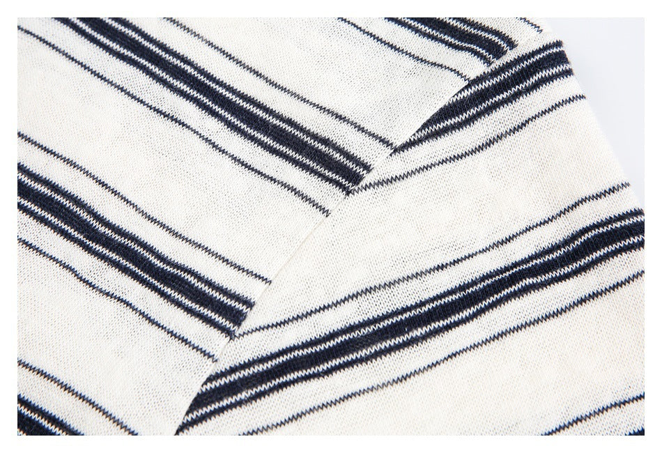 Close-up of a seam in cream knit fabric patterned with navy stripes.
