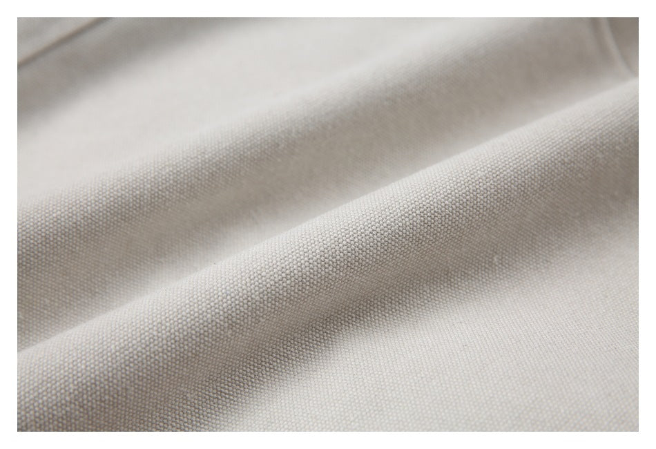 Macro view of the beige jacket’s textured woven surface and soft folds.