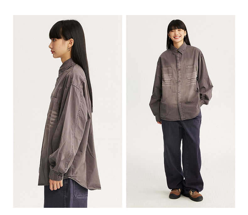 Two views of a model wearing an oversized smoky gray button-up shirt with chest pockets and dark trousers.