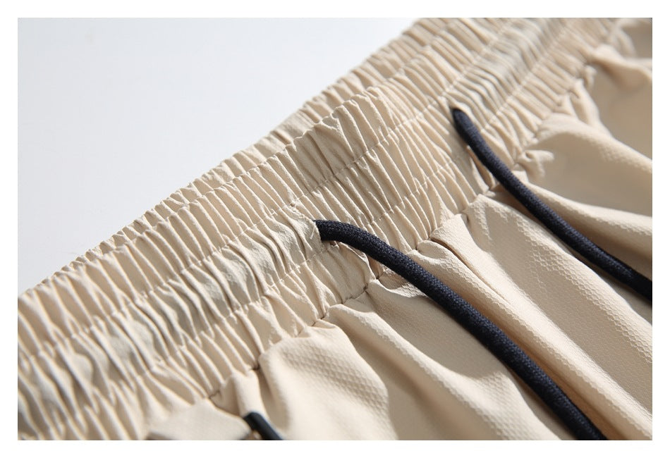 Close-up of the gathered cream waistband and black drawstrings.