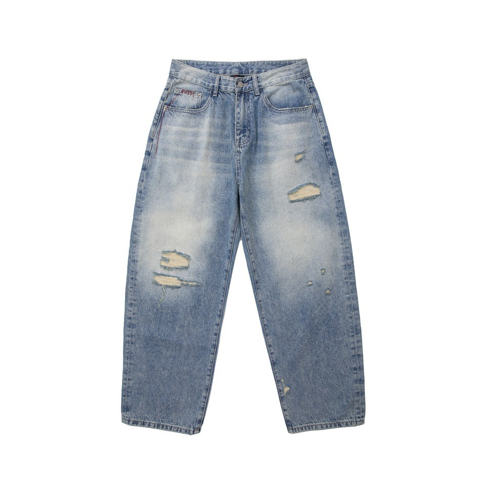 Front of light-blue faded wide-leg jeans with ripped patches on the legs, shown flat on a white background
