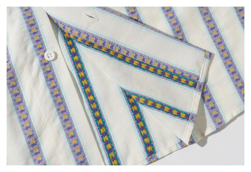Close-up of the shirt’s striped fabric, button, and folded seam with contrasting floral trim inside.