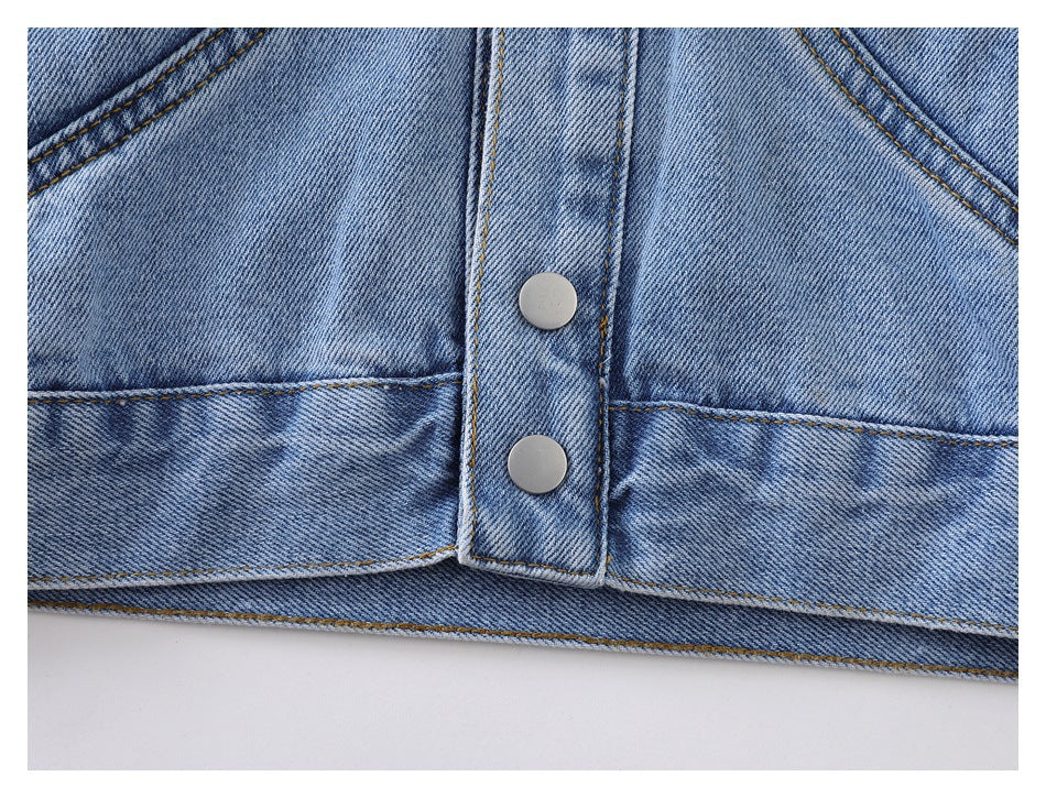 Close-up of the denim jacket hem, front placket, silver snaps, and horizontal seams.