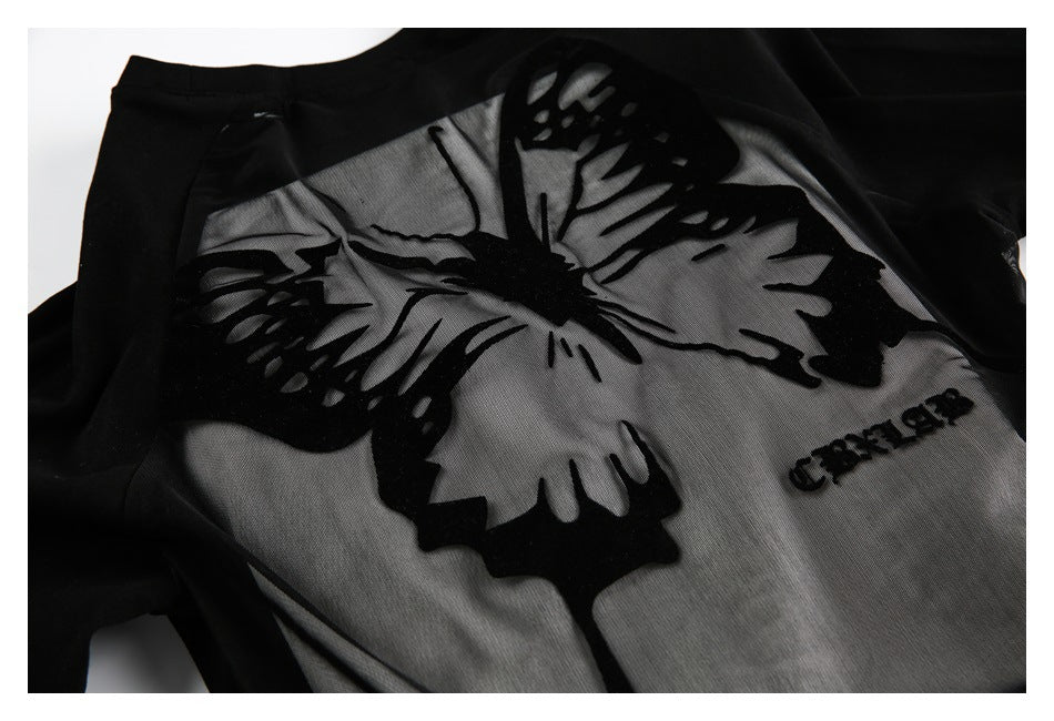 Black garment detail with a large butterfly design across sheer gray mesh panels and small embroidered lettering.