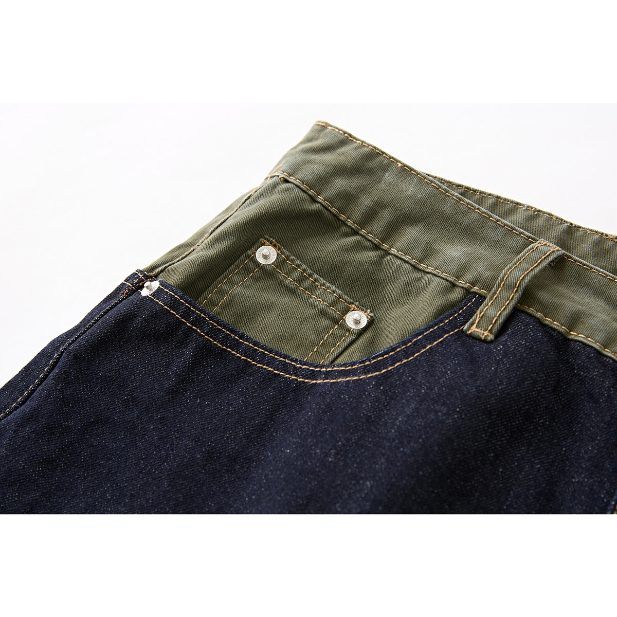 Close-up of the olive-green waistband and small riveted pocket above dark indigo denim shorts.