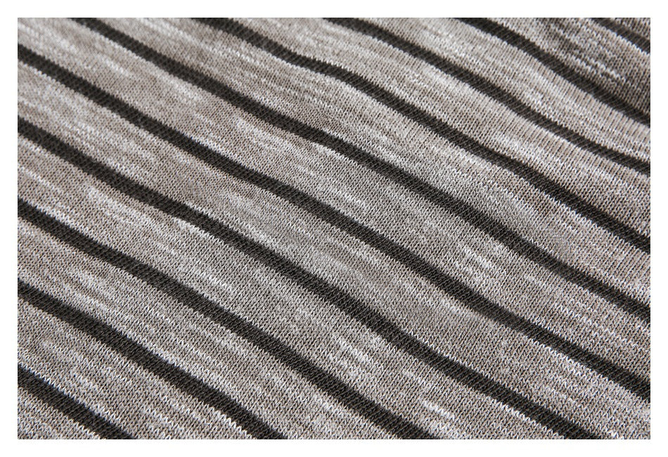 Close-up of gray knitted fabric with narrow diagonal black stripes.