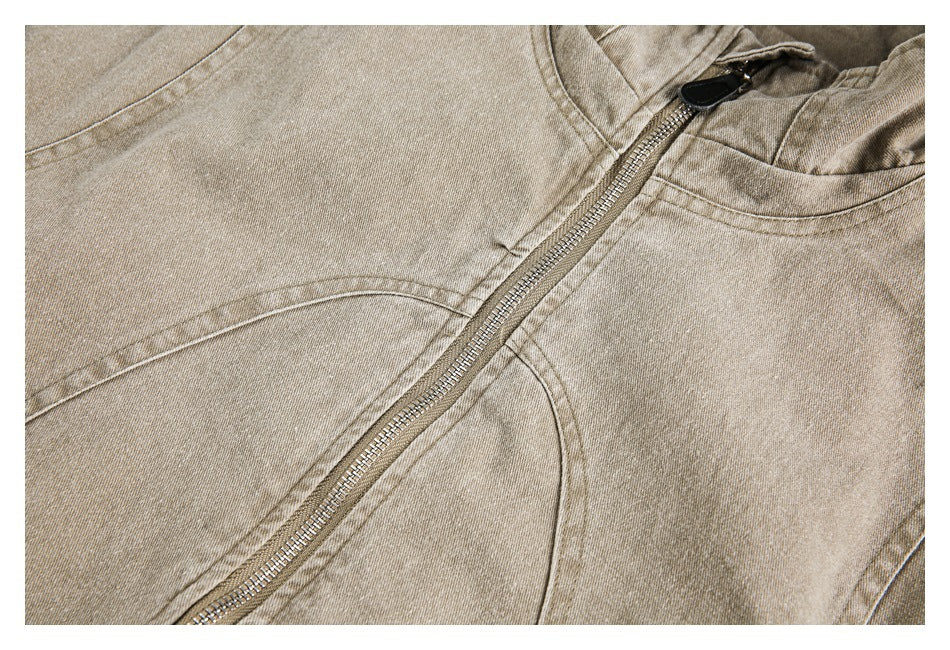 Close-up of a tan jacket's front zipper, curved seams, and collar edge.