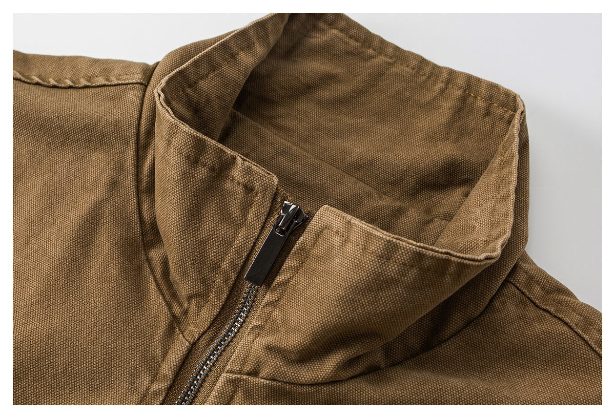 Close-up of a brown textured jacket's raised collar and front zipper.