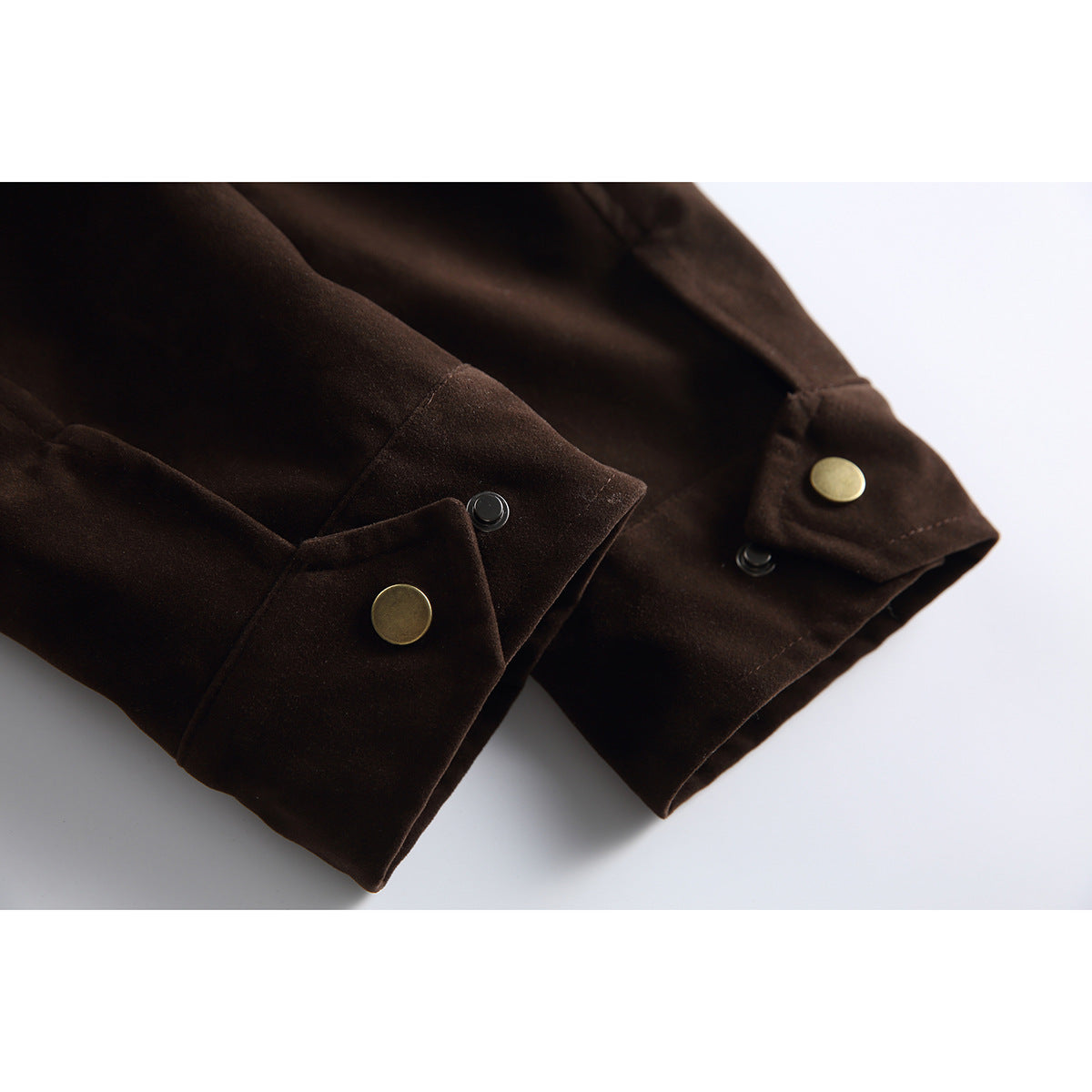 Close-up of dark brown jacket cuffs with brass snap buttons and black snap fasteners.