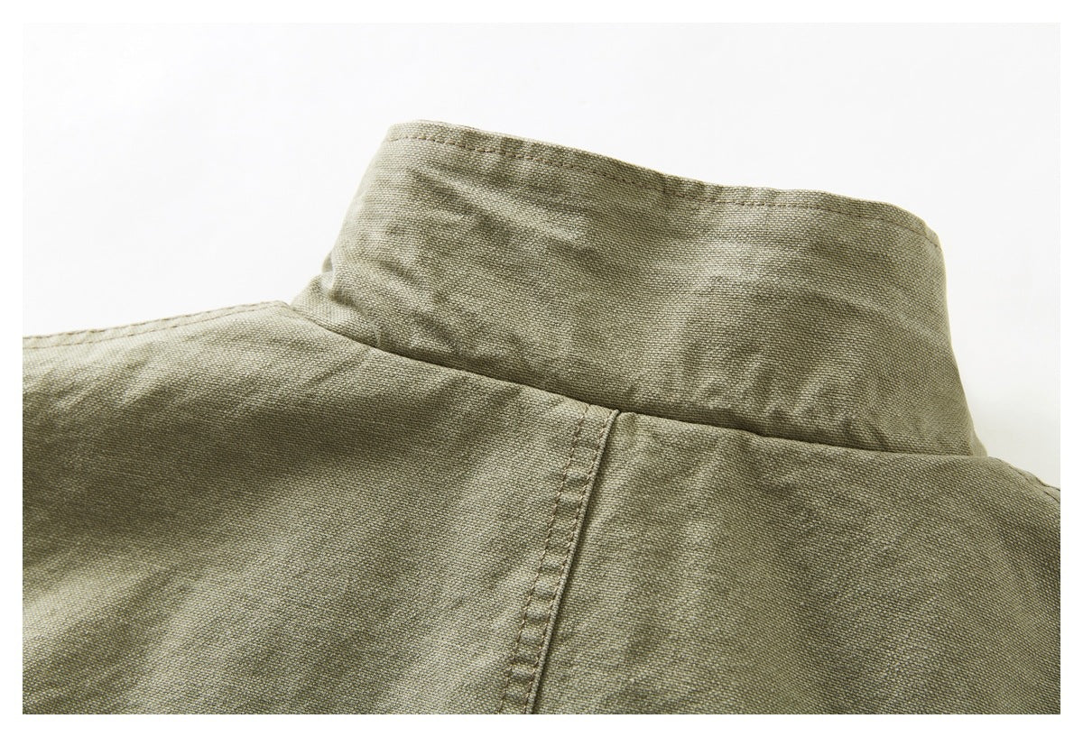 Close-up of the standing collar and back shoulder seam of an olive khaki jacket.