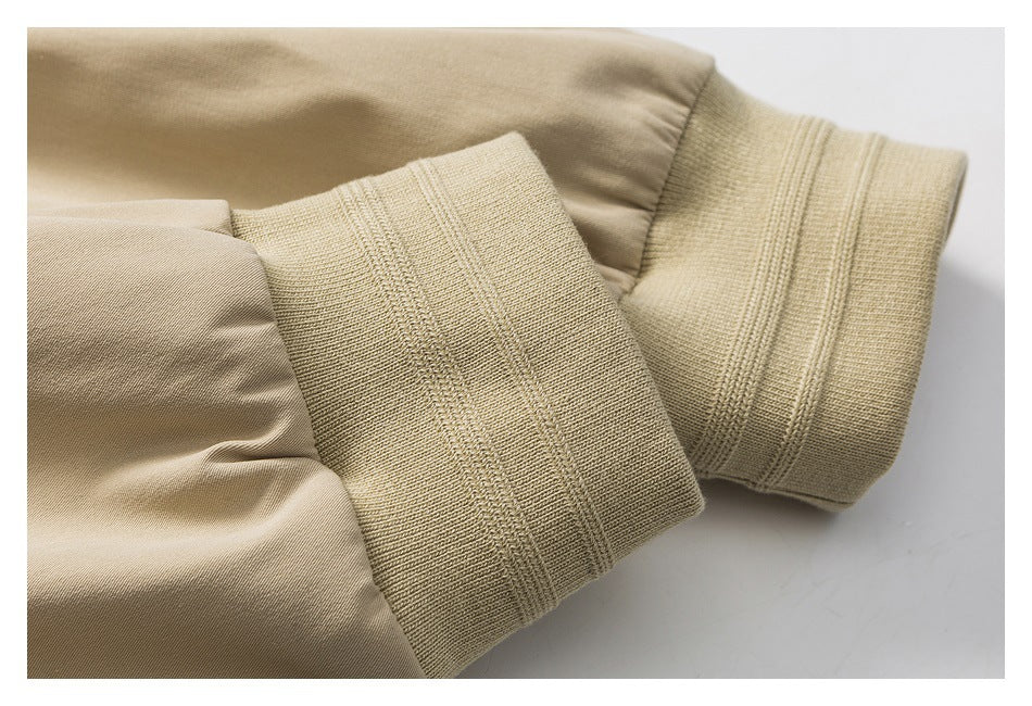 Close-up of beige jacket sleeves with wide rib-knit cuffs.