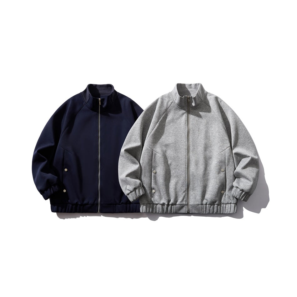 Front view of two zip-front jackets with stand collars and gathered hems, one navy and one gray.