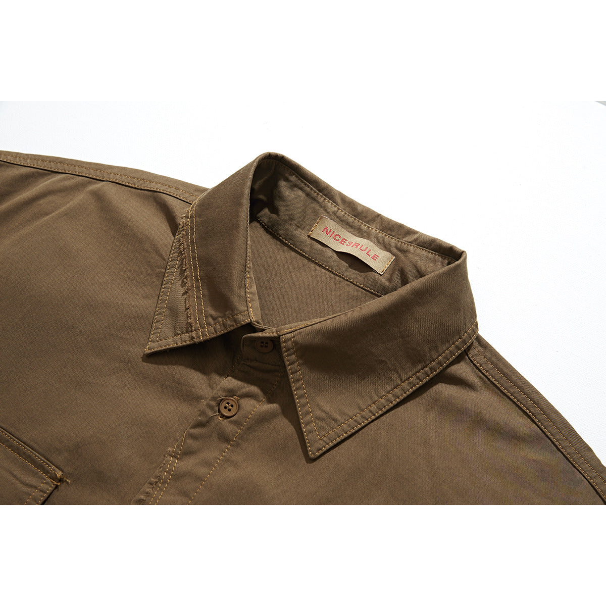 Close-up of a brown shirt collar, buttons, contrast stitching, and sewn-in neck label.