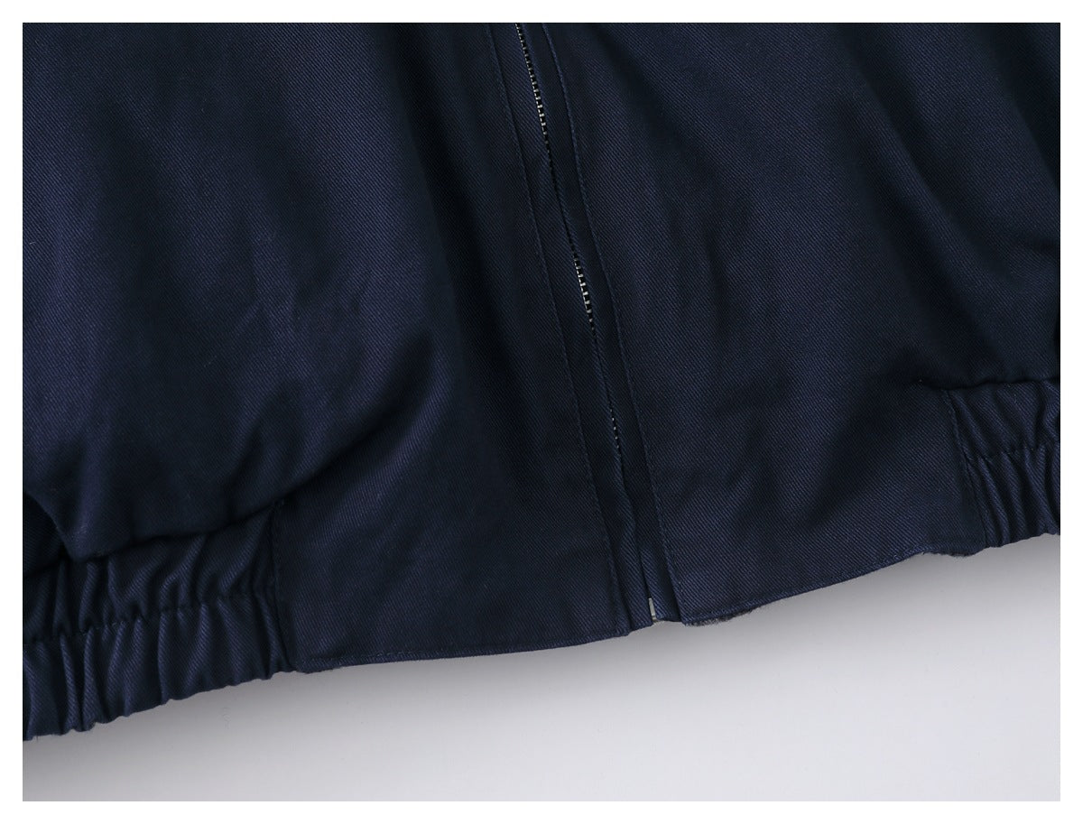 Close-up of the dark navy jacket's front zipper and gathered elastic hem.