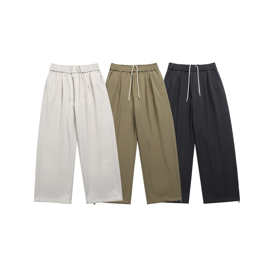 Three pairs of wide-leg drawstring trousers shown from the front in light beige, olive and dark charcoal.