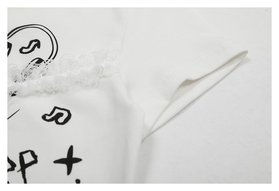 Close-up of a white garment edge with stitching, sheer lace trim, and partial black music-themed print.