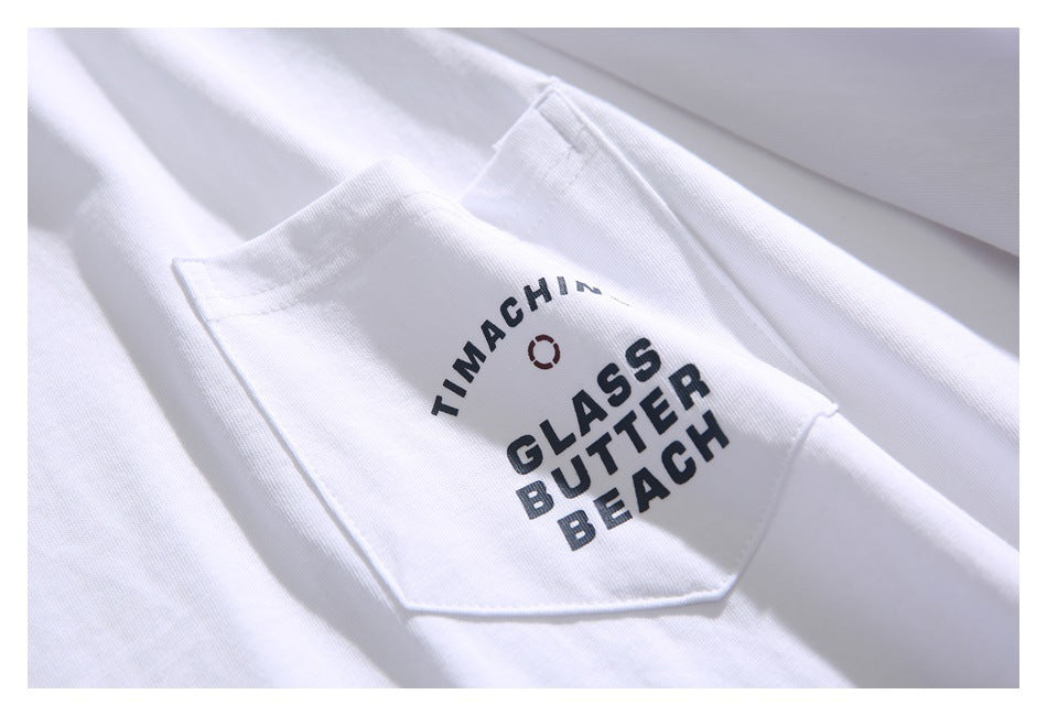 Close-up of a white T-shirt chest pocket printed with black English lettering and a small circular graphic.