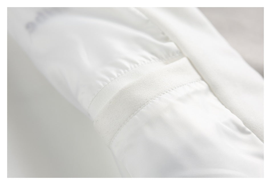Close-up of an ivory jacket sleeve and cuff construction with a soft-textured band.