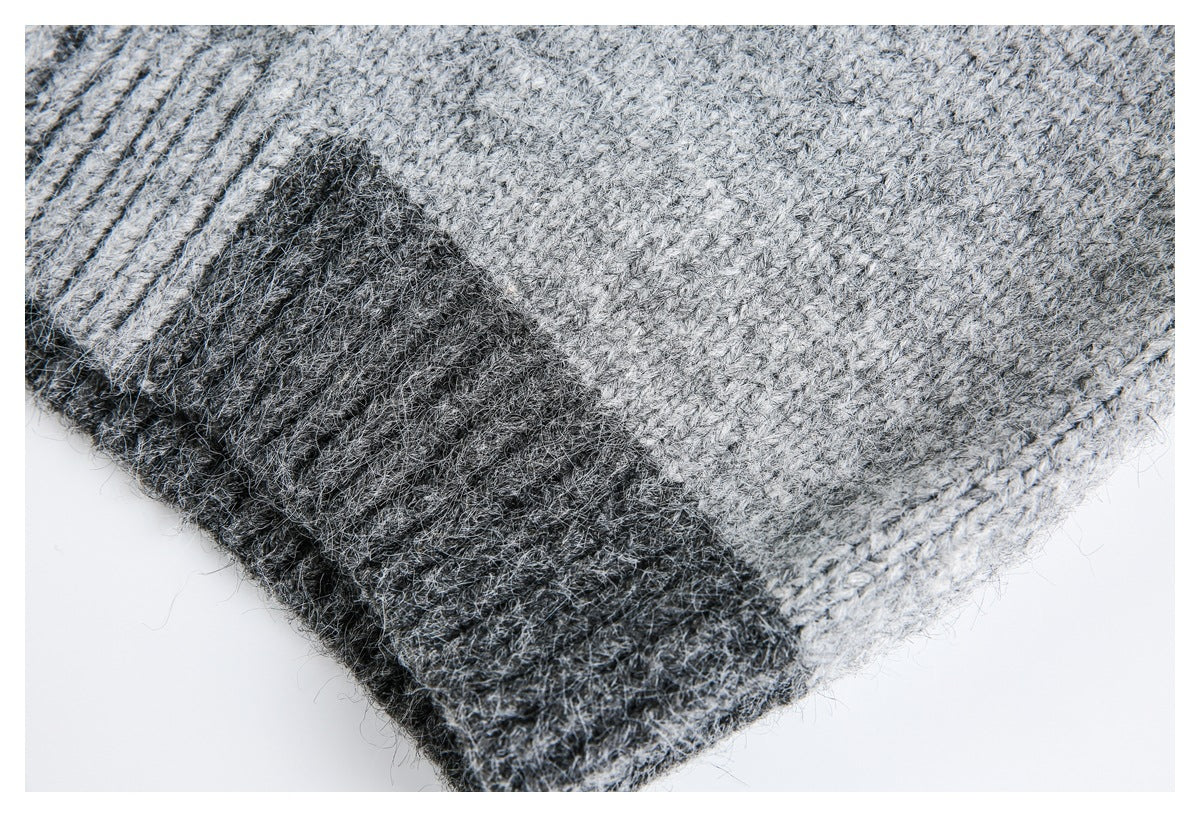Close-up of a dark gray ribbed edge against light gray marled knit fabric.