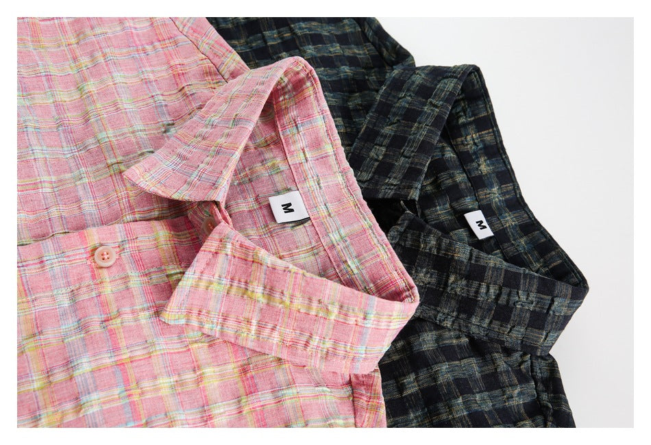 Two plaid shirts laid together: one pink with pastel stripes and one dark navy with muted stripes.
