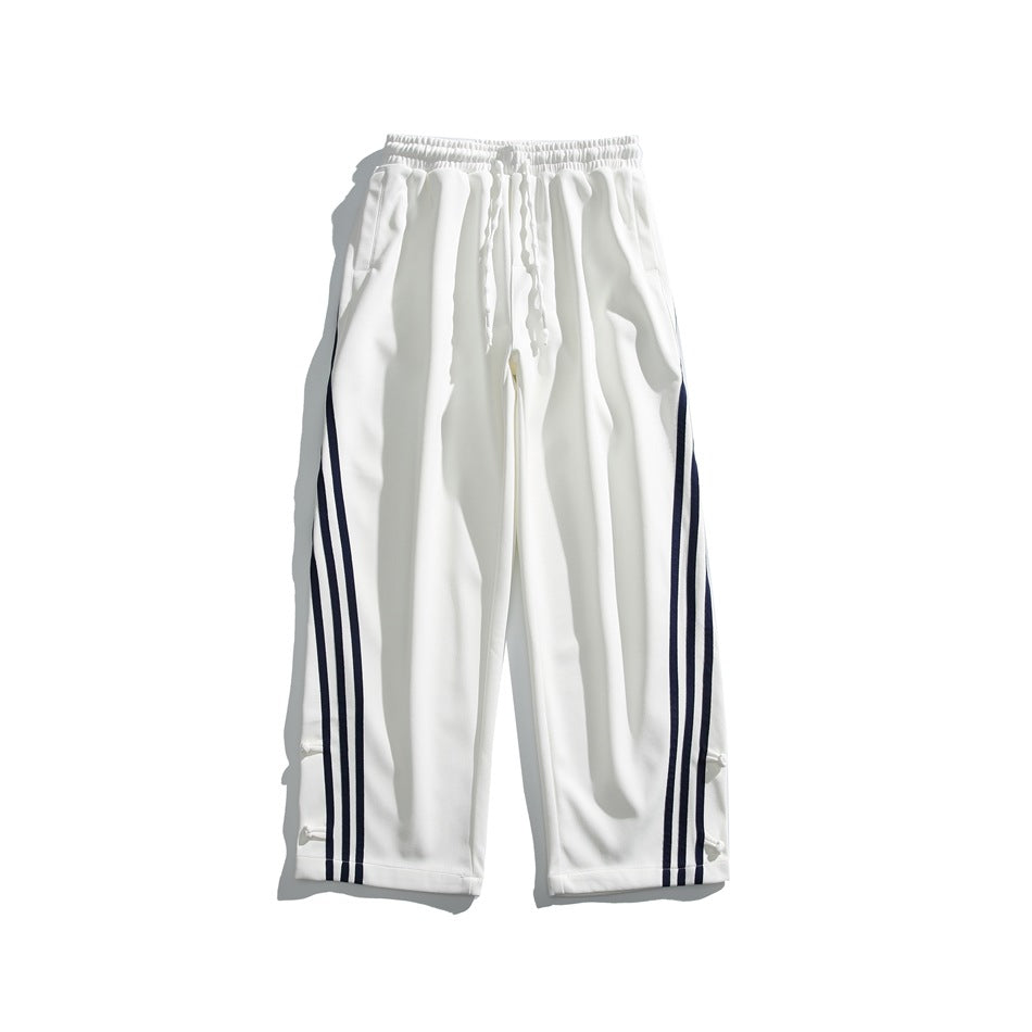 White wide-leg pants with elastic drawstring waist and navy three-stripe side detail, flat lay front view