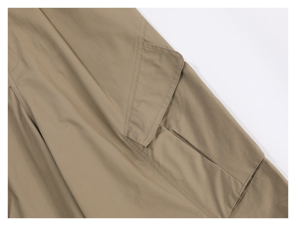 Close-up of a khaki trouser cargo pocket flap and stitched pocket opening.