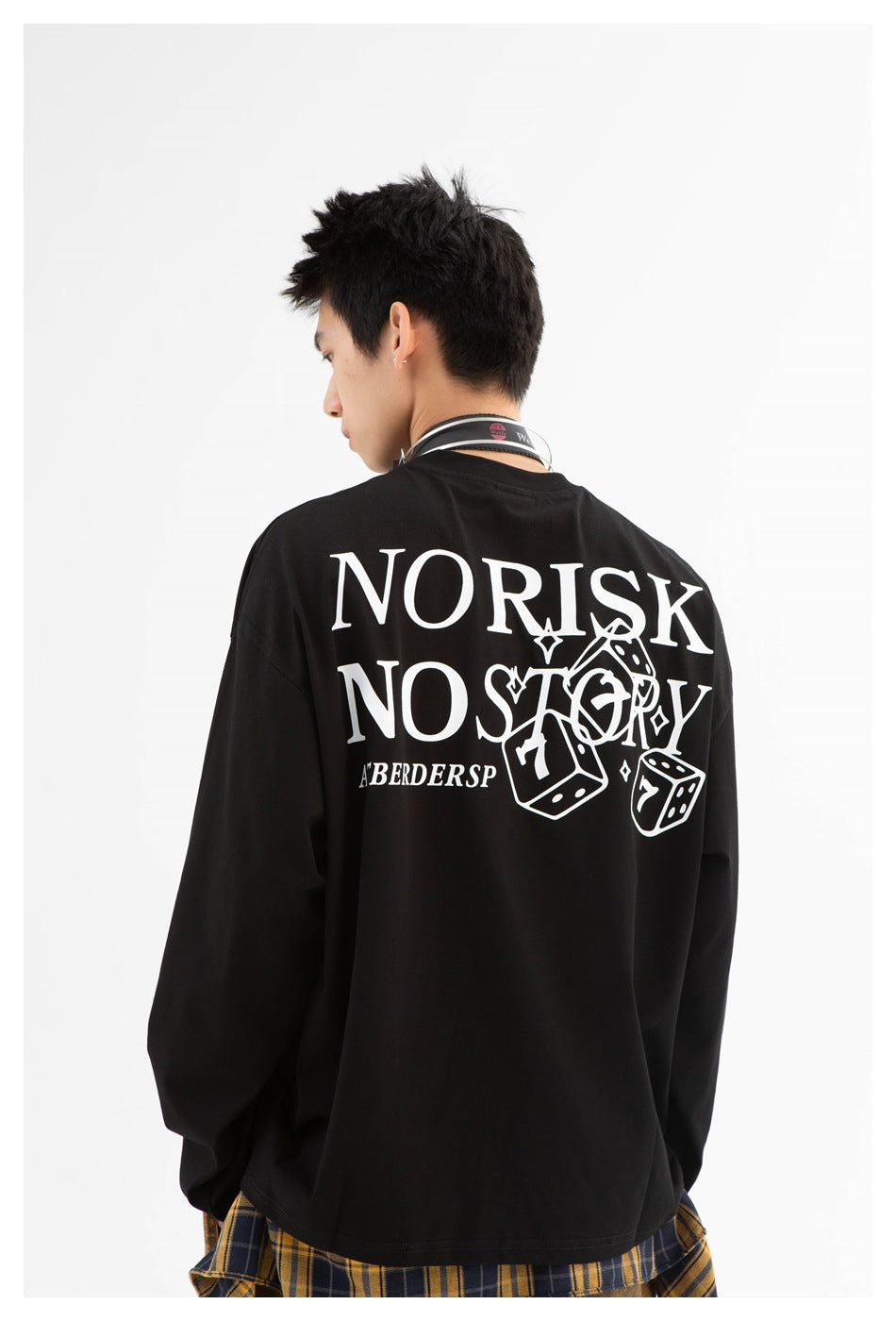 Back view of a model wearing a black long-sleeve shirt with large white text and dice artwork.