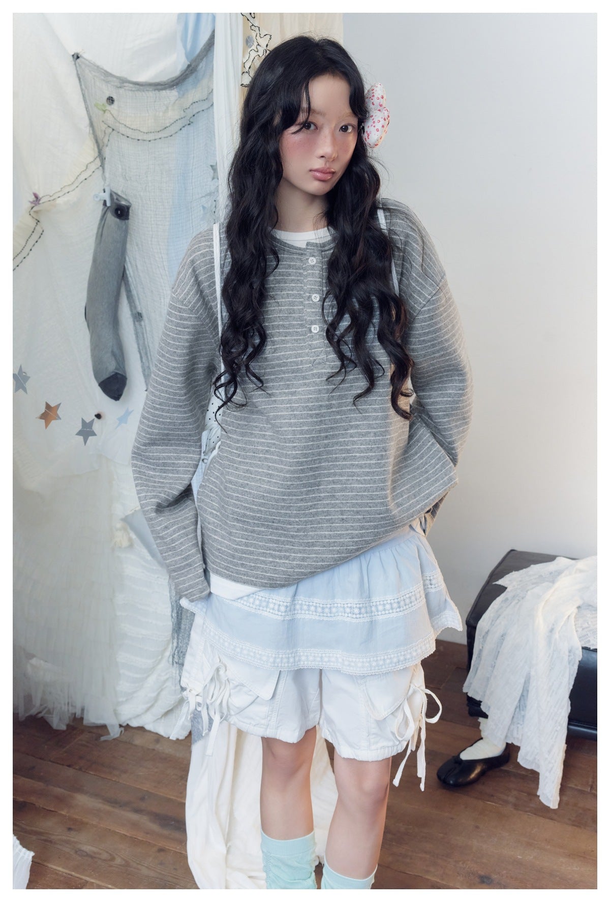 Closer view of a model wearing a gray-and-white striped long-sleeve henley with a short button placket.