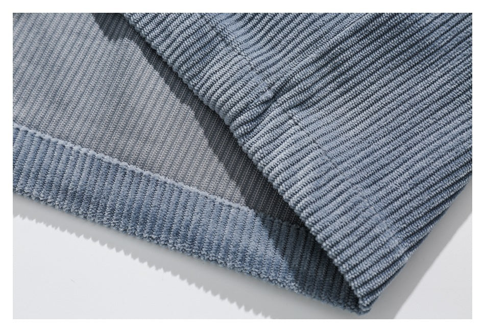 Close-up of the hem and stitching on light blue ribbed pants.