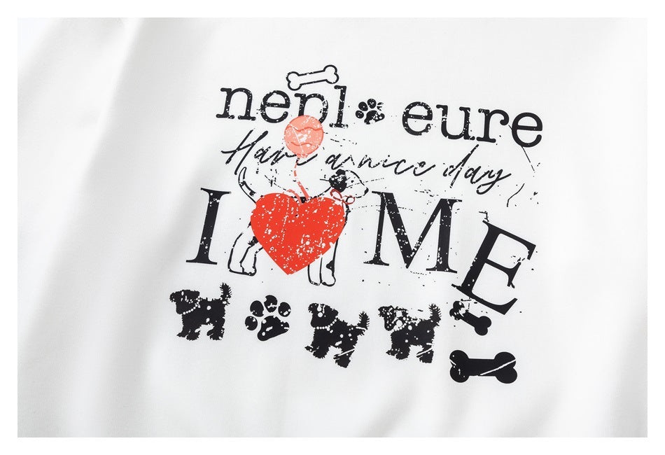 Close-up of a white garment printed with black lettering, dog illustrations and paw prints, plus a red heart and balloon.