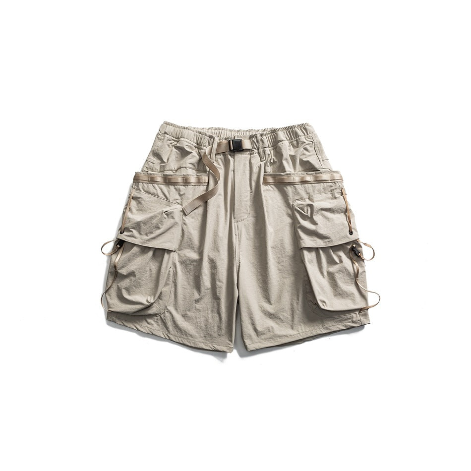 Light gray-beige cargo shorts flat lay with webbing belt, large flap pockets and side strap loops
