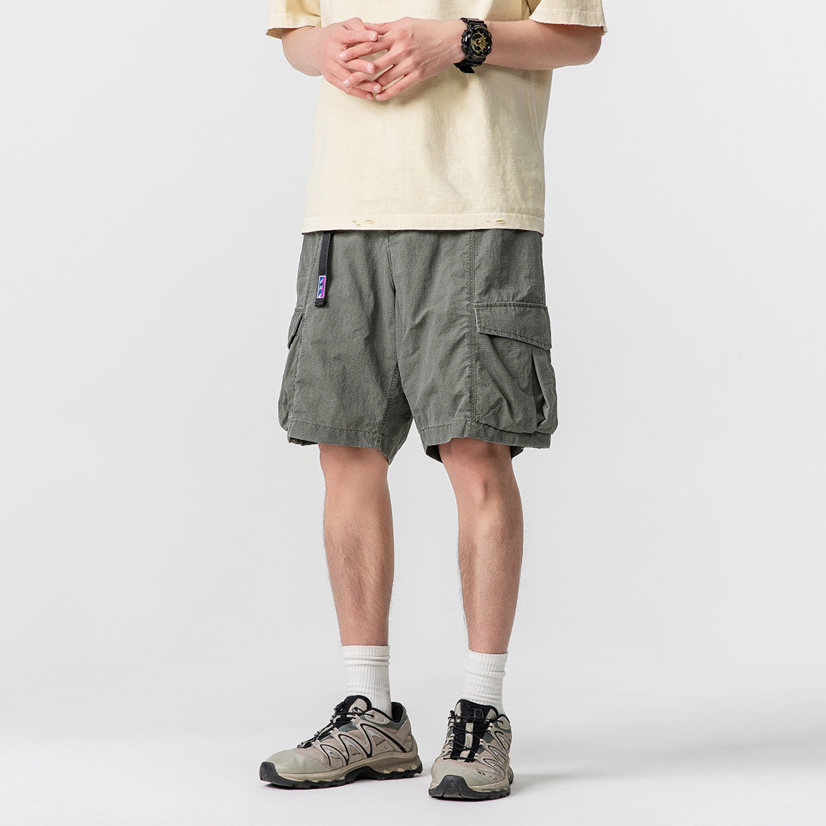 Front view of a model wearing loose charcoal-gray cargo shorts with roomy flap pockets.