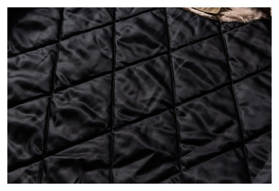Close-up of black diamond-quilted jacket lining with a small edge of beige fur visible.