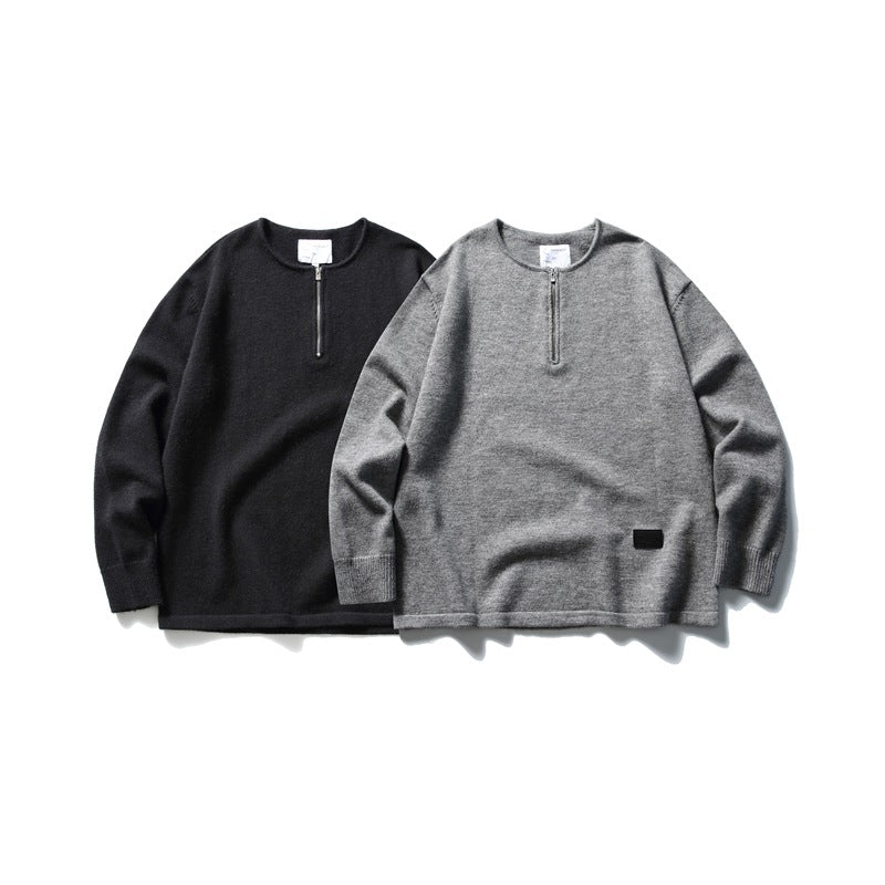 Black and gray long-sleeve knit tops with short front zippers, shown from the front.