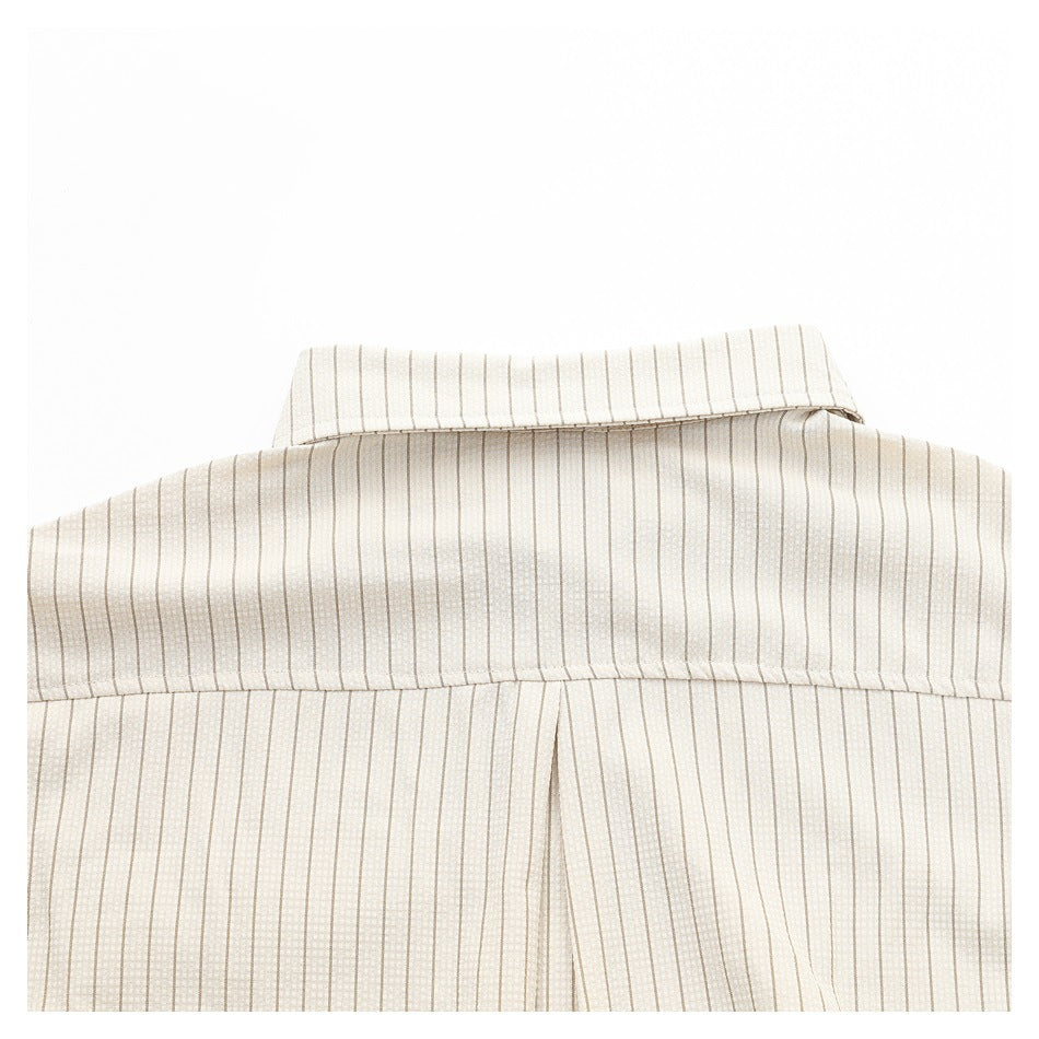 Close-up of a cream shirt back with fine vertical beige stripes, showing the collar, yoke seam, and pleat.