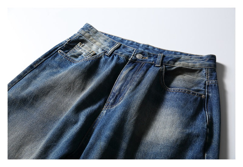 Close-up of the front waist, pockets, and faded blue denim of wide-leg jeans.