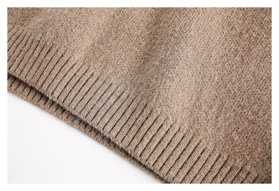 Close-up of a taupe-brown knit garment showing a wide ribbed edge and textured stitches.
