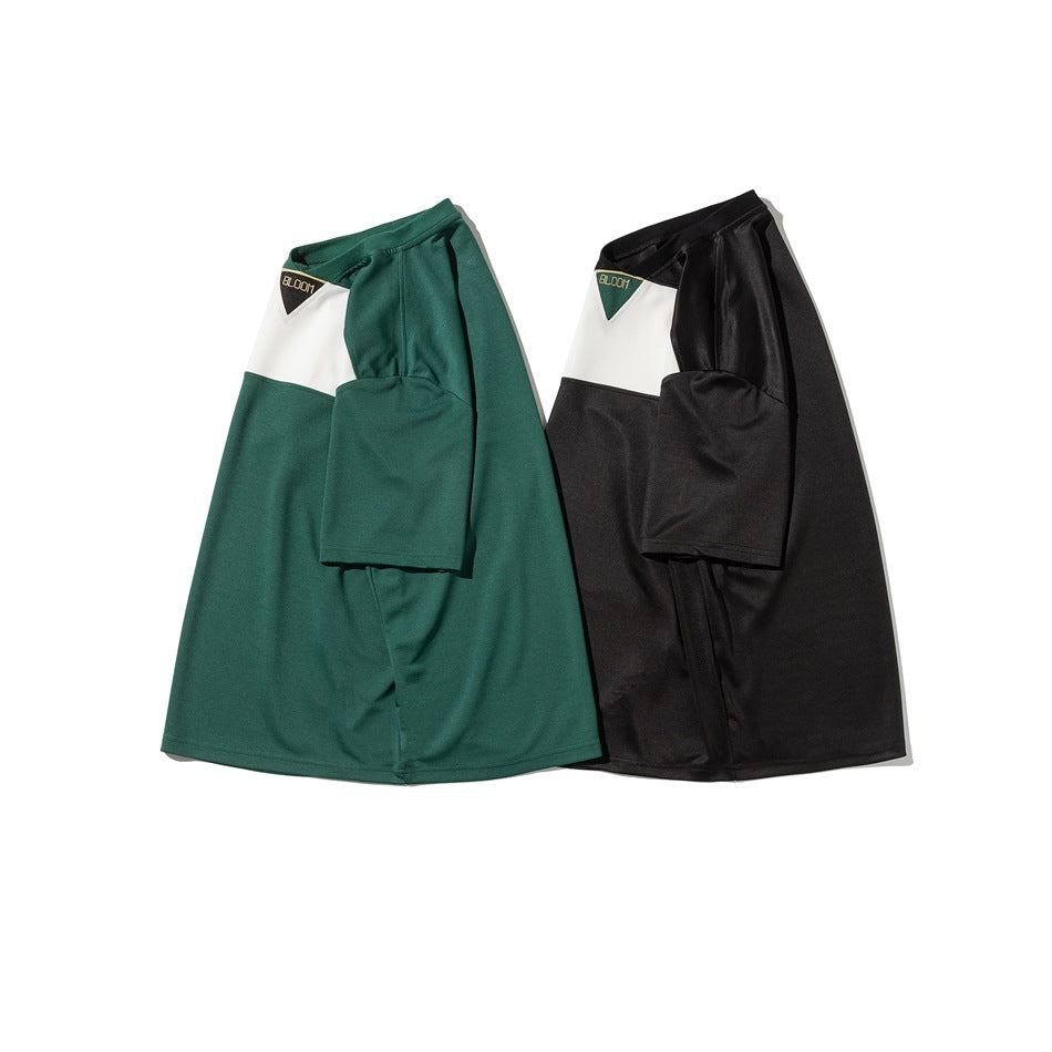 Two short-sleeve color-block T-shirts in dark green and black, with white chest panels and small triangular chest patches.