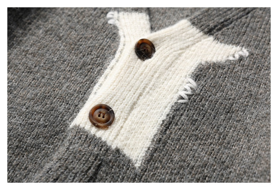 Close-up of a gray knit cardigan's white contrast button placket with two brown buttons.