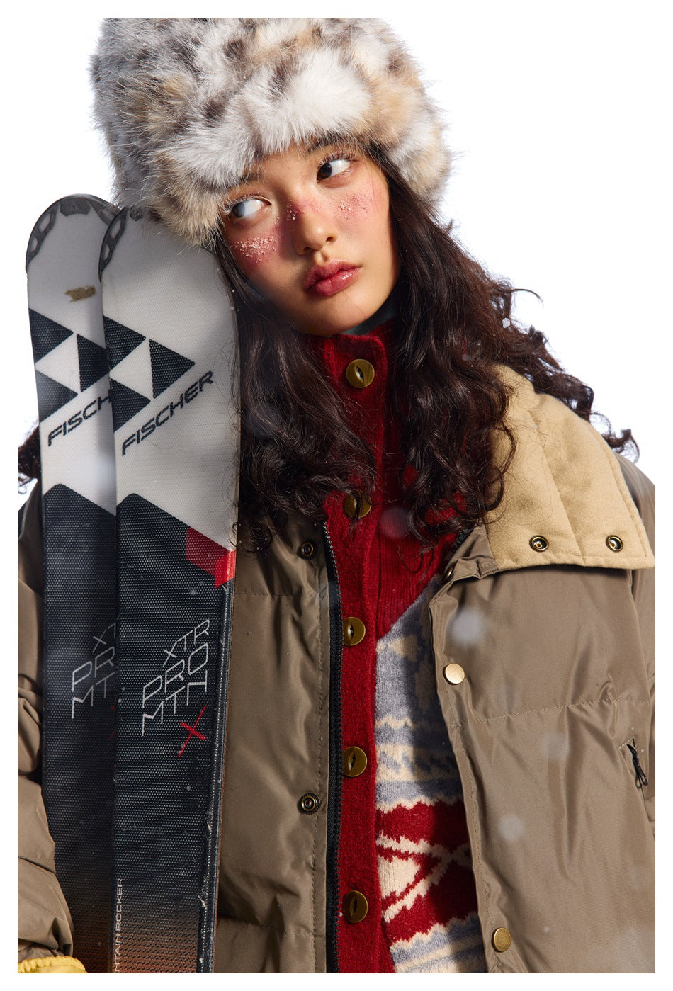 Close view of a model wearing a taupe padded jacket with a tan collar and brass-tone snaps.