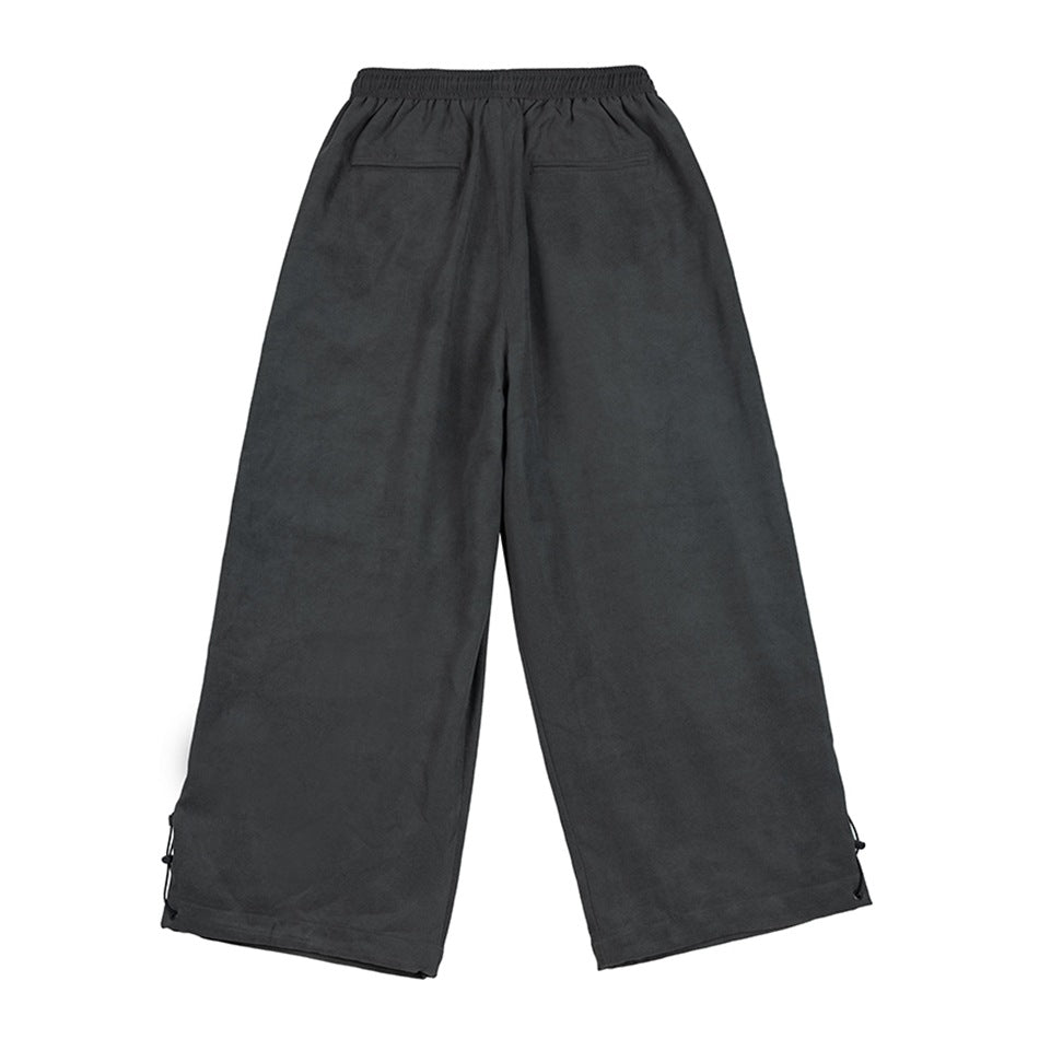 Back view of charcoal gray wide-leg pants with an elastic waist, two rear pockets, and adjustable ankle cords.