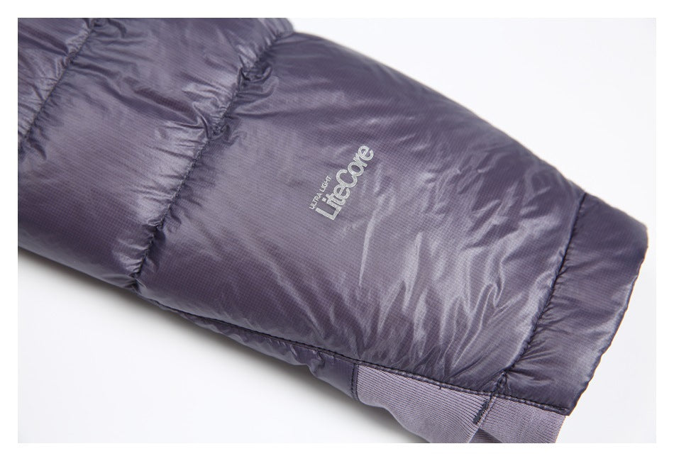Close-up of a dark purple jacket sleeve with a small light-colored logo and ribbed cuff.