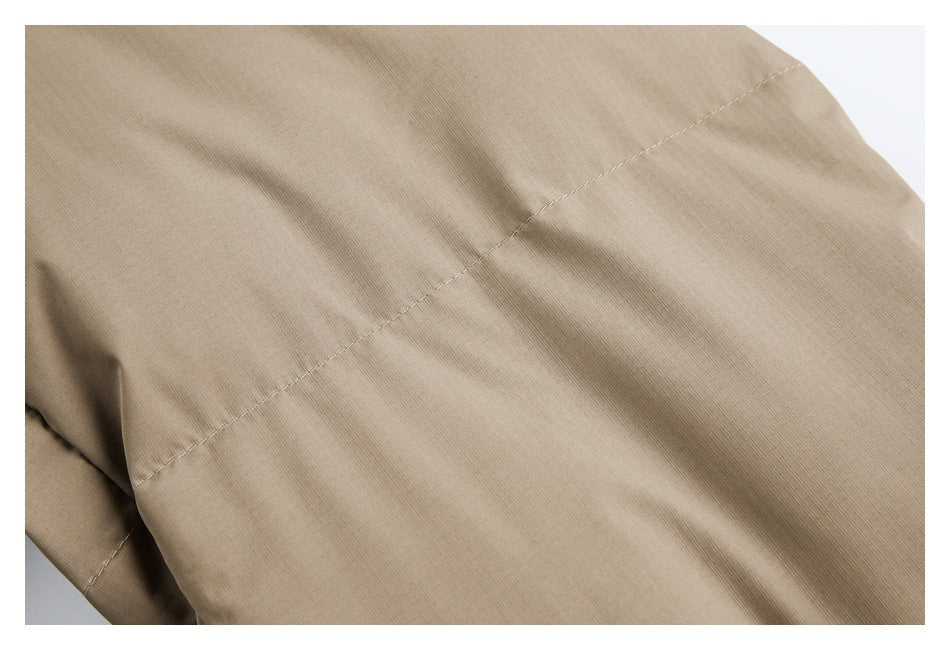 Close-up of tan garment fabric with a diagonal stitched seam.